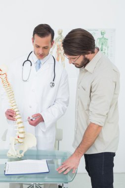 bir hasta için omurga açıklayan erkek doktor