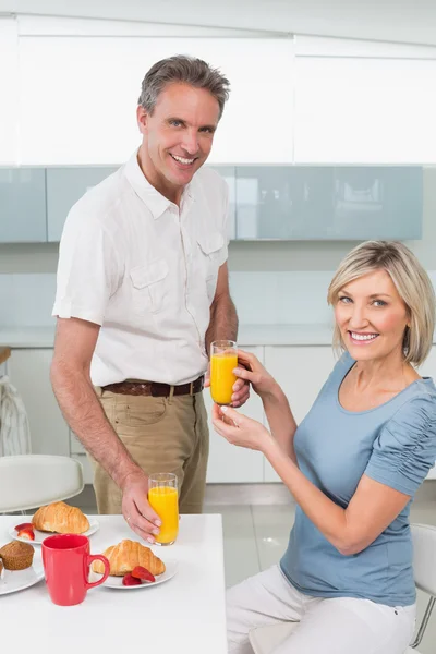 Casal feliz tomando café da manhã na cozinha — Fotografia de Stock