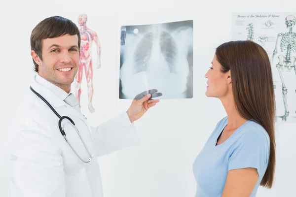 Male doctor explaining lungs x-ray to female patient — Stock Photo, Image