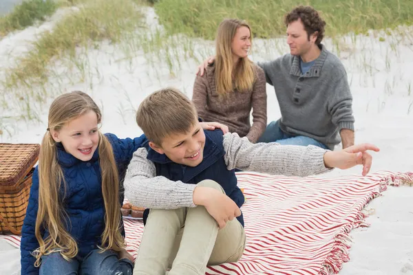 Gelukkige familie van vier op een strand picknick — Stockfoto