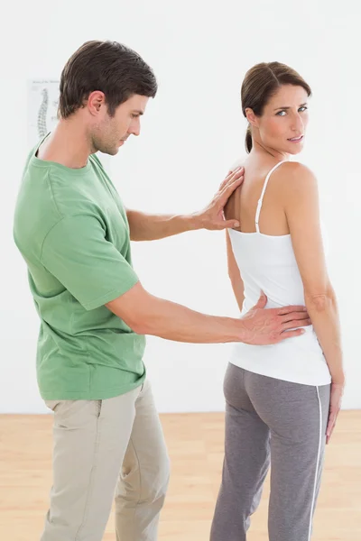 Physiotherapist examining woman's back in medical office — Stock Photo, Image