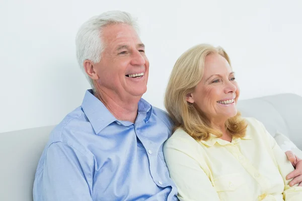 Relaxed loving senior couple sitting on sofa — Stock Photo, Image