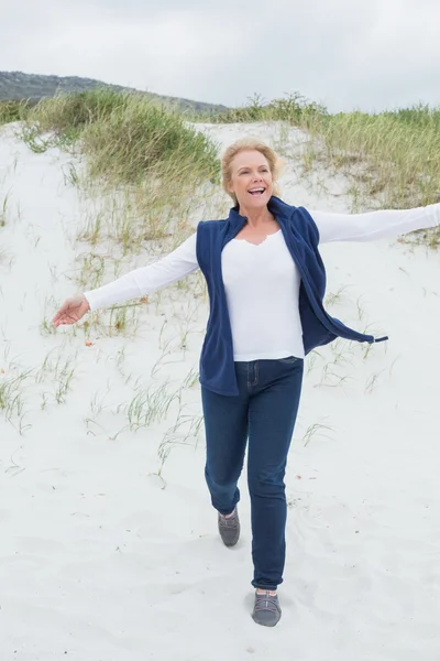 Glückliche Seniorin läuft am Strand — Stockfoto