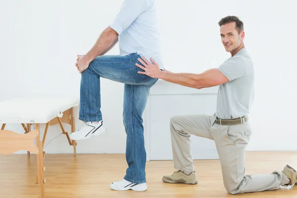 Side view of a male physiotherapist examining man's back — Stock Photo, Image