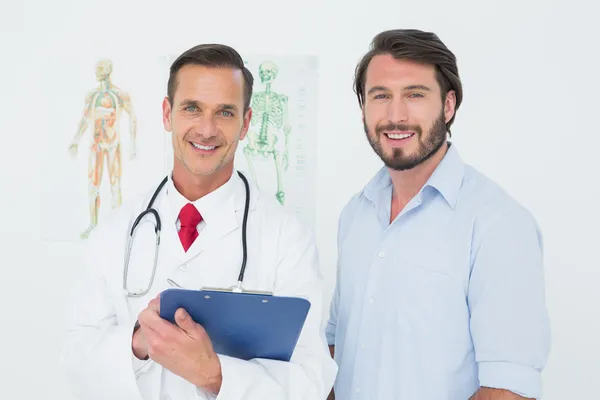 Portrait of a male doctor and patient with reports — Stock Photo, Image