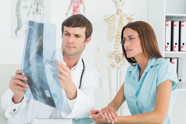 Médico varón explicando la radiografía espinal al paciente femenino —  Fotos de Stock