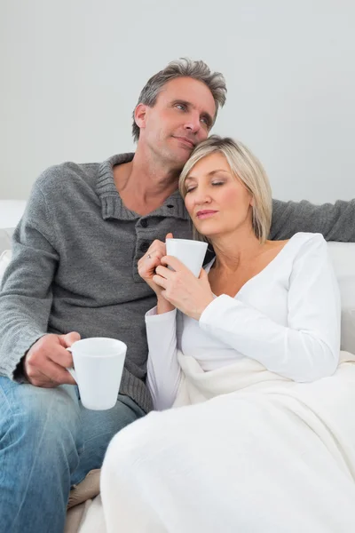 Relaxed couple with coffee cups in living room — Stock Photo, Image