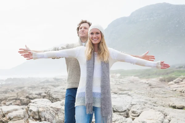 Casual couple stretching hands out on rocky landscape — Stock Photo, Image