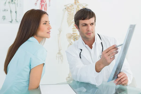 Doctor explicando la radiografía a una paciente femenina en el consultorio médico — Foto de Stock