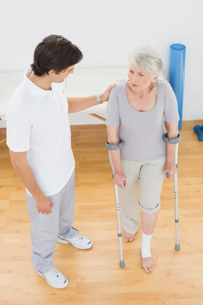 Mannelijke therapeut in discussie met een handicap senior patiënt — Stockfoto