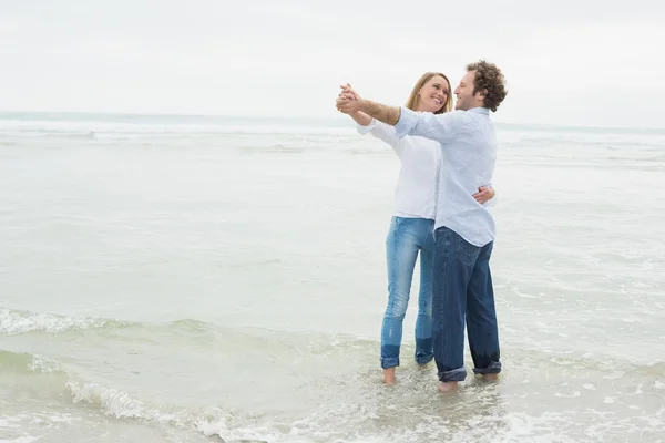 Tout au long de la danse un couple à la plage — Stockfoto