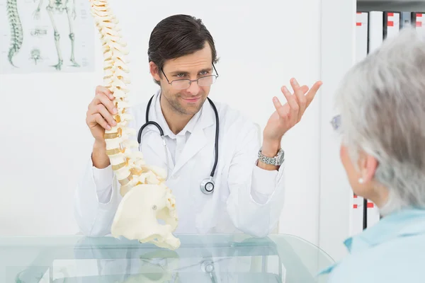 Erkek doktor omurganın üst düzey bir hastaya açıklanması — Stok fotoğraf