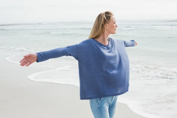 Donna con gli occhi chiusi e le braccia distese in spiaggia — Foto Stock