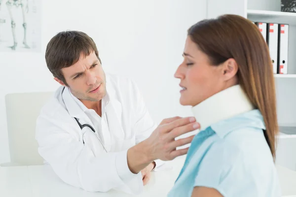 Médico examinando el cuello de un paciente en el consultorio médico —  Fotos de Stock