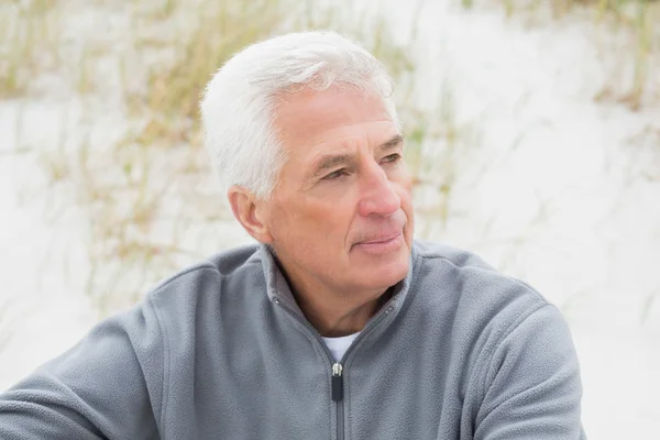 Smiling casual senior man relaxing at beach — Stock Photo, Image