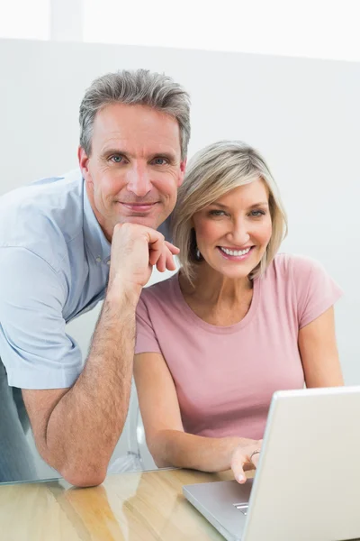 Zufriedenes Paar nutzt Laptop zu Hause — Stockfoto