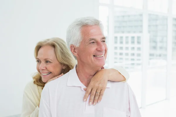 Happy senior woman embracing man from behind — Stock Photo, Image