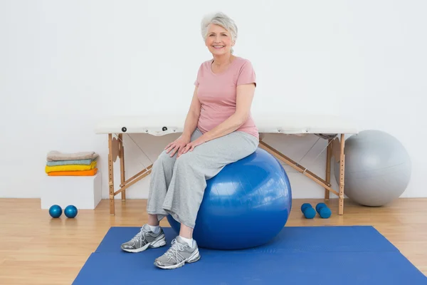 Portret van een senior vrouw zittend op de fitness bal — Stockfoto