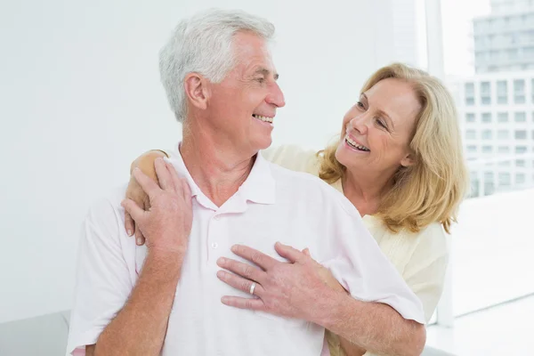 Happy senior kvinna omfamnar man bakifrån — Stockfoto