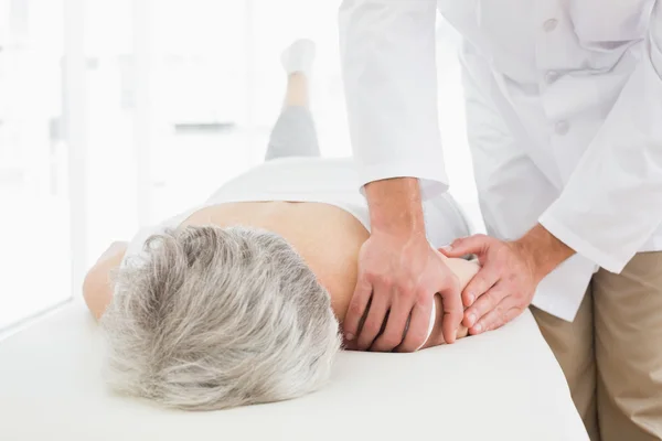 Physiotherapist massaging a senior woman's shoulder — Stock Photo, Image