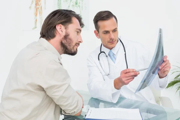 Male doctor explaining spine x-ray to patient — Stok fotoğraf