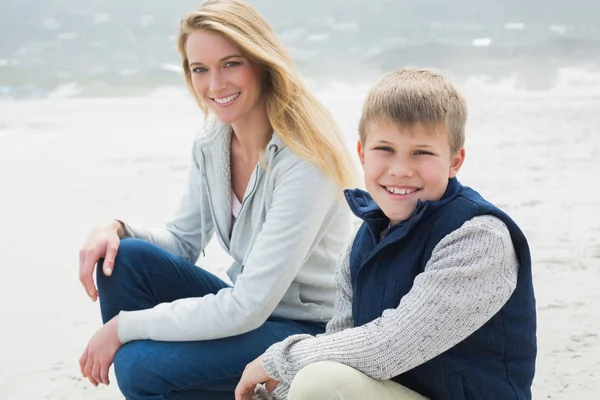 Mujer casual y su hijo relajándose en la playa — Foto de Stock