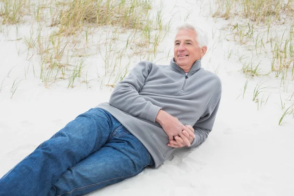 Смолящий случайный пожилой человек, отдыхающий на пляже — стоковое фото