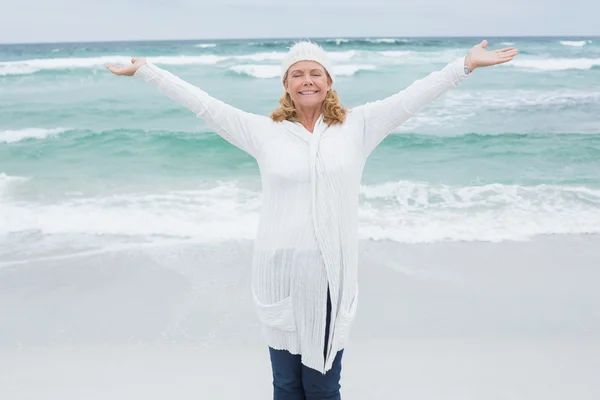 Casual senior woman with arms outstretched at beach — Stock Photo, Image