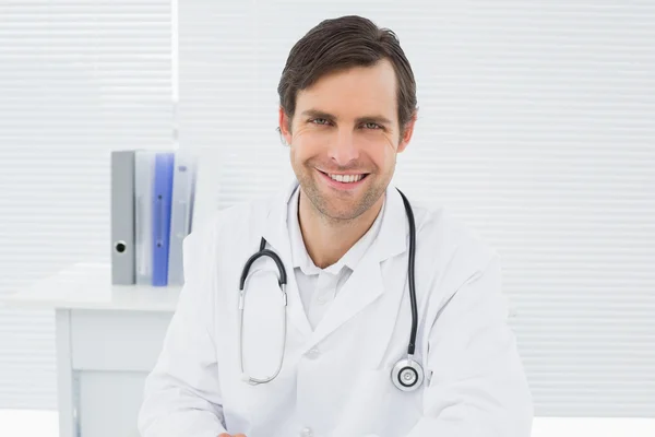 Usmívající se jistý muž lékař v ordinaci — Stock fotografie