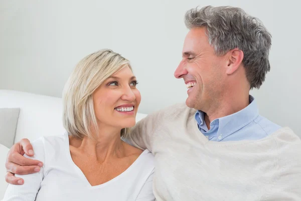 Pareja feliz sentada en el salón — Foto de Stock