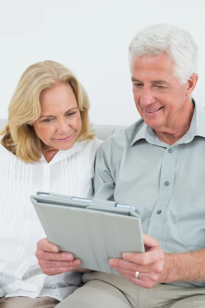 Relajado feliz pareja de ancianos utilizando tableta digital —  Fotos de Stock