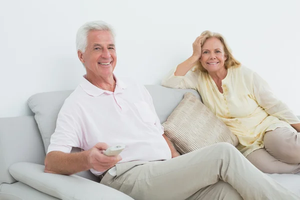 Senior couple with remote control at home — Stock Photo, Image