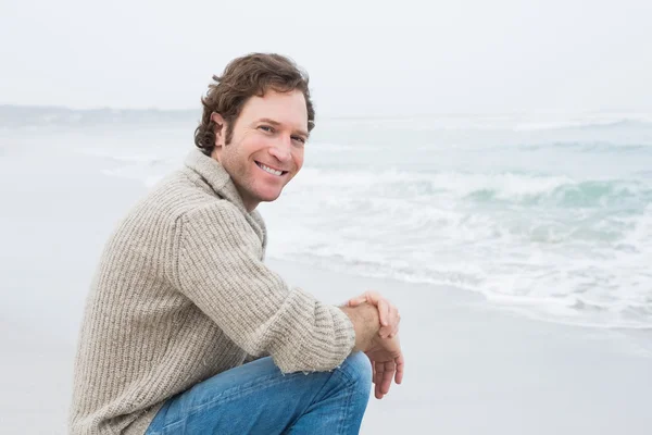 Улыбающийся молодой человек расслабляется на пляже — стоковое фото