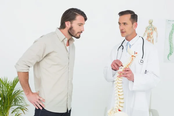 Bir hasta için omurga açıklayan erkek doktor — Stok fotoğraf