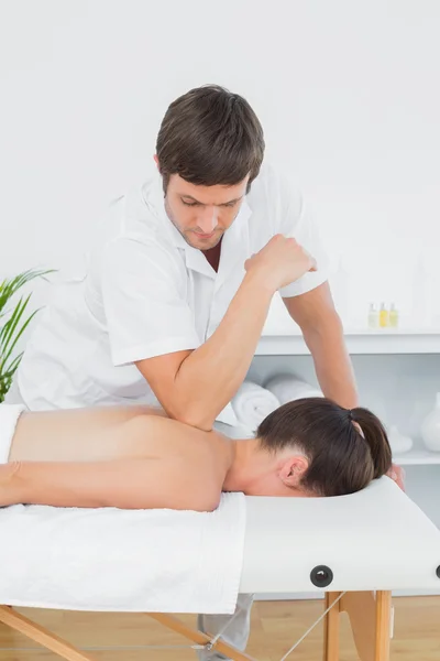 Чоловік фізіотерапевт масажує спину жінки — стокове фото