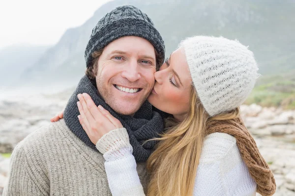 Woman kissing a man on rocky landscape — Stock Photo, Image