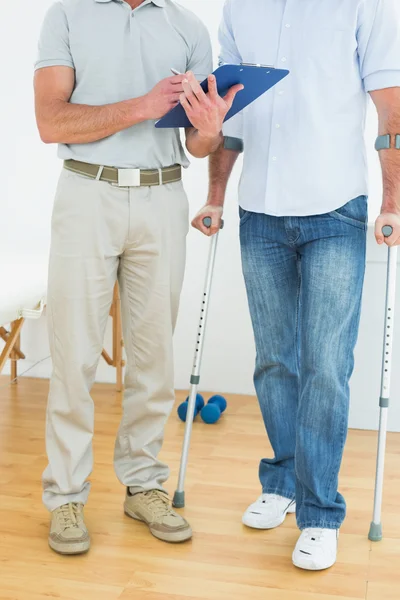 Therapist and disabled patient with reports — Stock Photo, Image