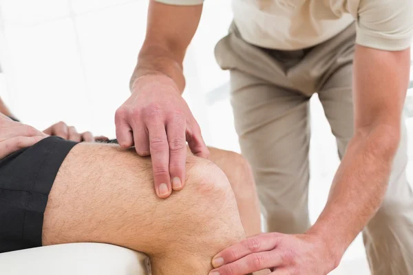 Primer plano en la sección media de un hombre que se hace examinar la rodilla — Foto de Stock