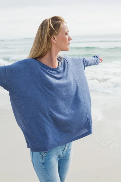 Donna con le braccia distese sulla spiaggia — Foto Stock