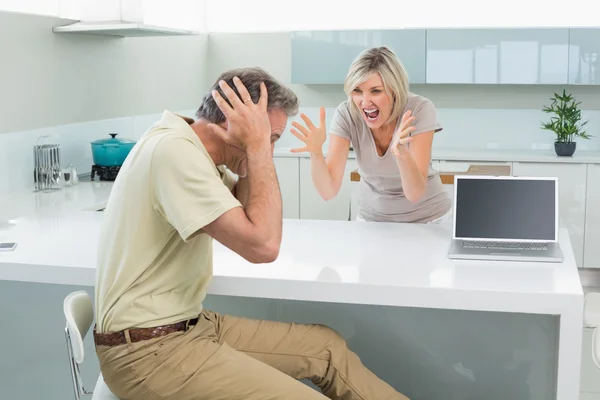 Hombre cubriendo sus oídos como mujer discutir en la cocina — Foto de Stock