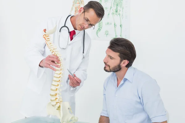 Male doctor explaining the spine to a patient — Stock Photo, Image