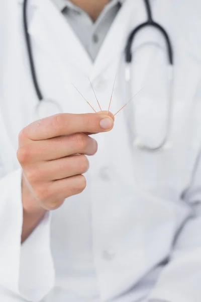 Középső szakasz egy férfi orvos holding akupunktúrás tűk — Stock Fotó
