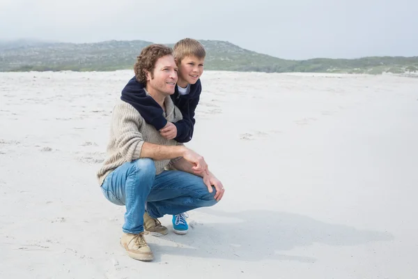 Zijaanzicht van een toevallige man en zoon ontspannen op het strand — Stockfoto