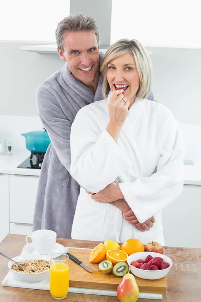 Мужчина обнимает счастливую женщину сзади на кухне — стоковое фото