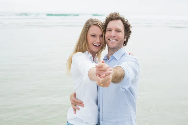 Portret van vrolijke paar dansen op strand — Stockfoto