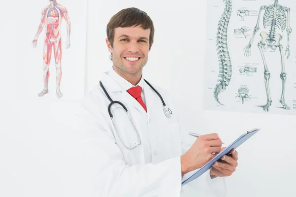 Male doctor holding clipboard in the medical office — Stock Photo, Image