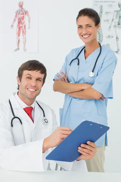 Médico y enfermera sonriente con informes — Foto de Stock