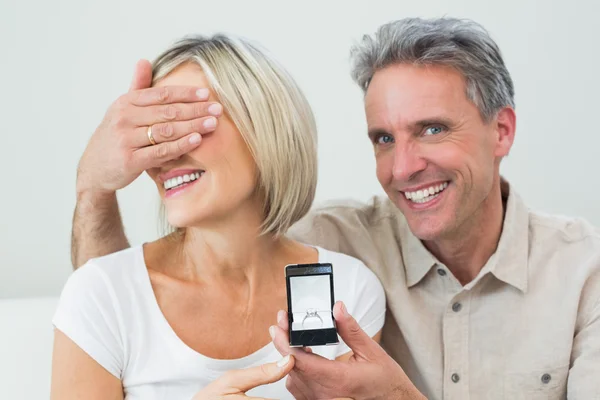 Hombre cubriendo los ojos de la mujer para ofrecerle un anillo de compromiso —  Fotos de Stock