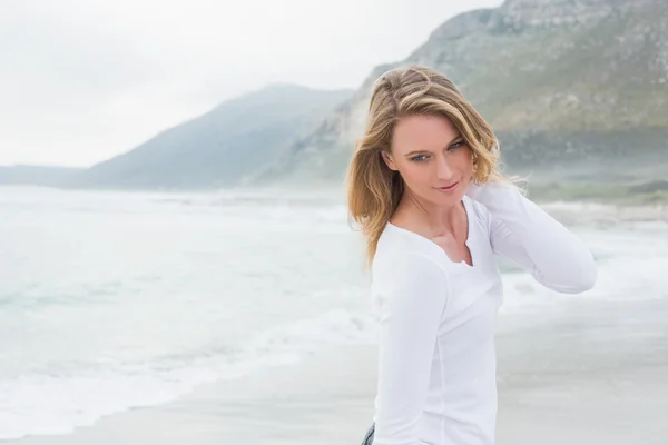 Donna sorridente guardando lontano in spiaggia — Foto Stock