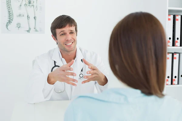 Doctor listening to patient with concentration in medical office — Stock Photo, Image